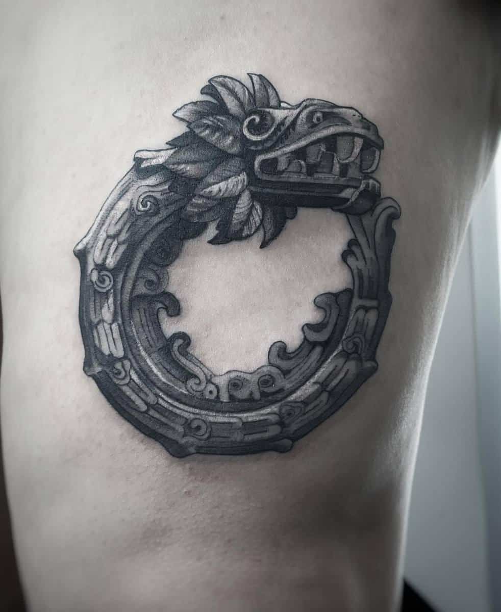 Black and grey Ouroboros Quetzalcoatl tattoo with intricate Aztec-inspired details, symbolizing eternity