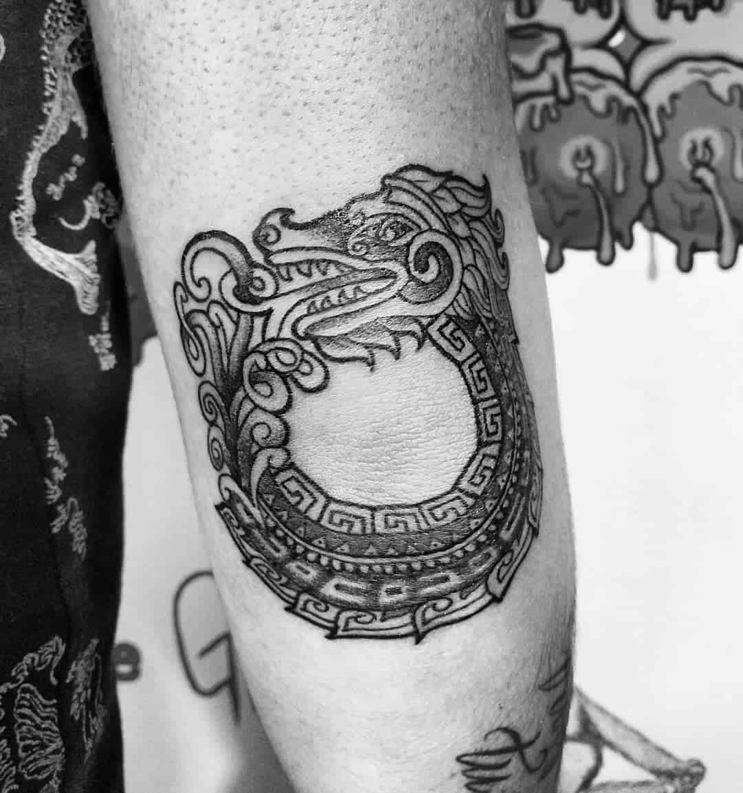 Bold linework Ouroboros Quetzalcoatl tattoo with intricate patterns and a detailed serpent head, symbolizing the cycle of life and eternity