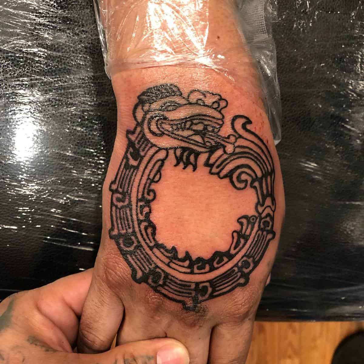 Hand tattoo of Quetzalcoatl depicted as a serpent eating its own tail, symbolizing infinity