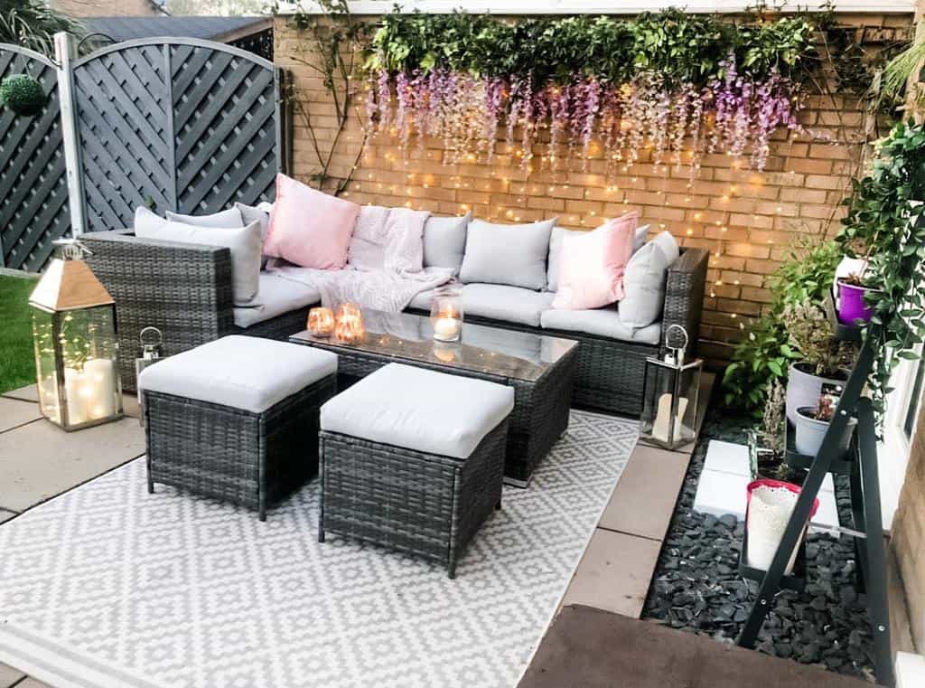 stone paver patio with floor rug and wicker furniture 