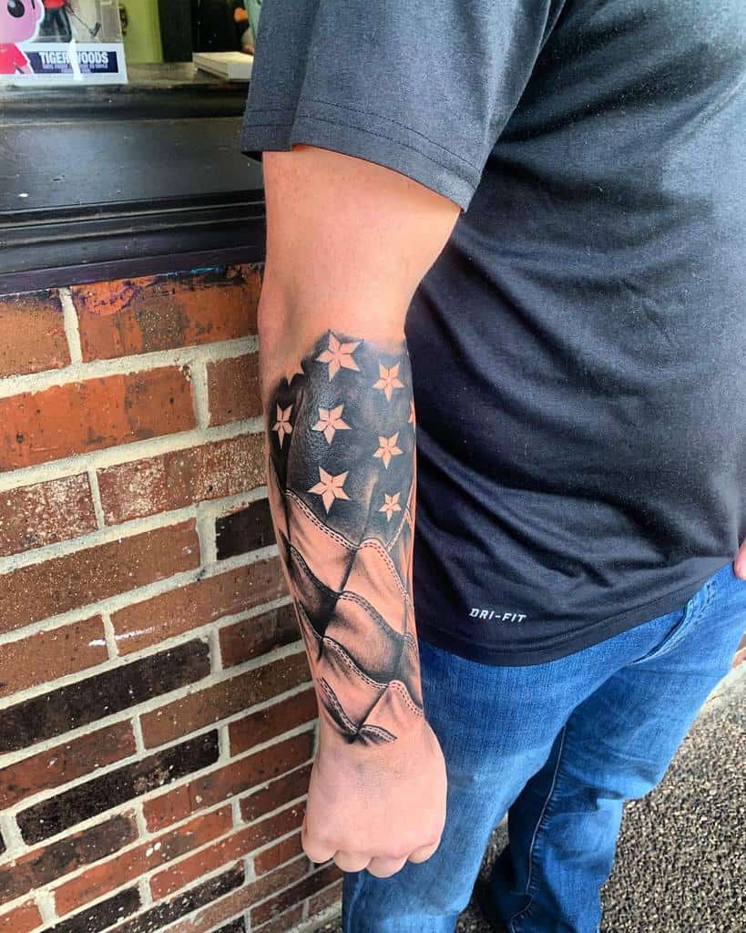 A man with an American flag tattoo on their outer forearm