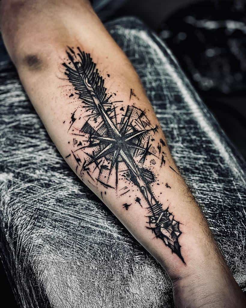 Outer forearm tattoo featuring a bold arrow and compass design with intricate shading and dotwork, symbolizing direction and strength.