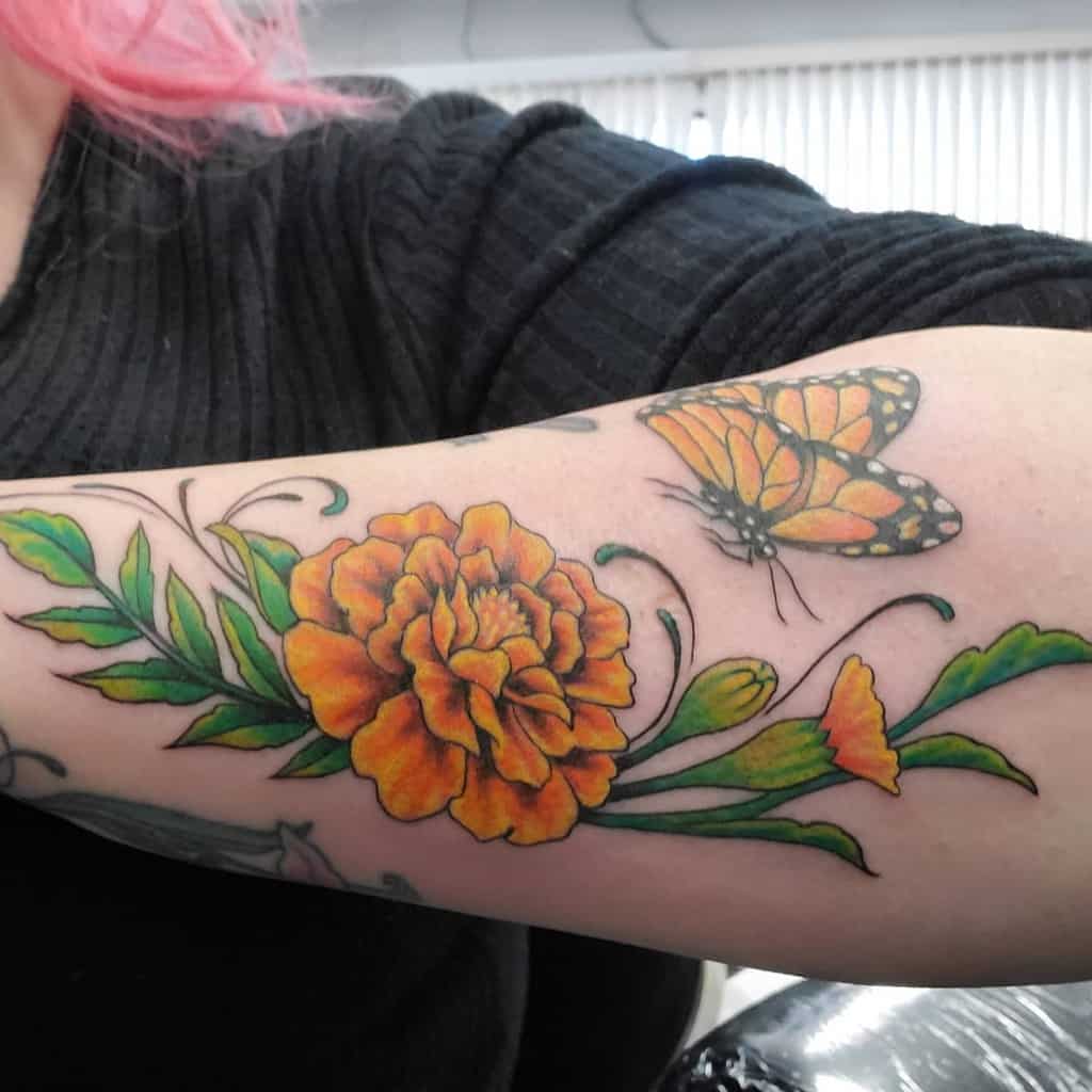 Tattoo of an orange flower and butterfly on a person's forearm