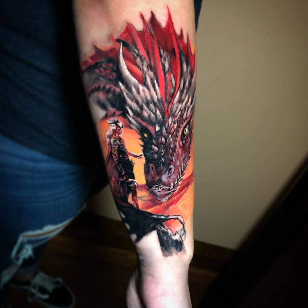 An outer forearm tattoo depicts a dragon intertwined with a knight on horseback, brought to life with vivid reds and oranges