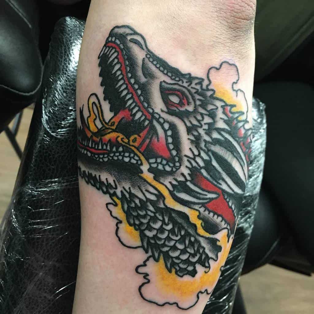 A vibrant dragon tattoo with flames adorns the outer forearm, adding a strikingly vivid masterpiece to the skin