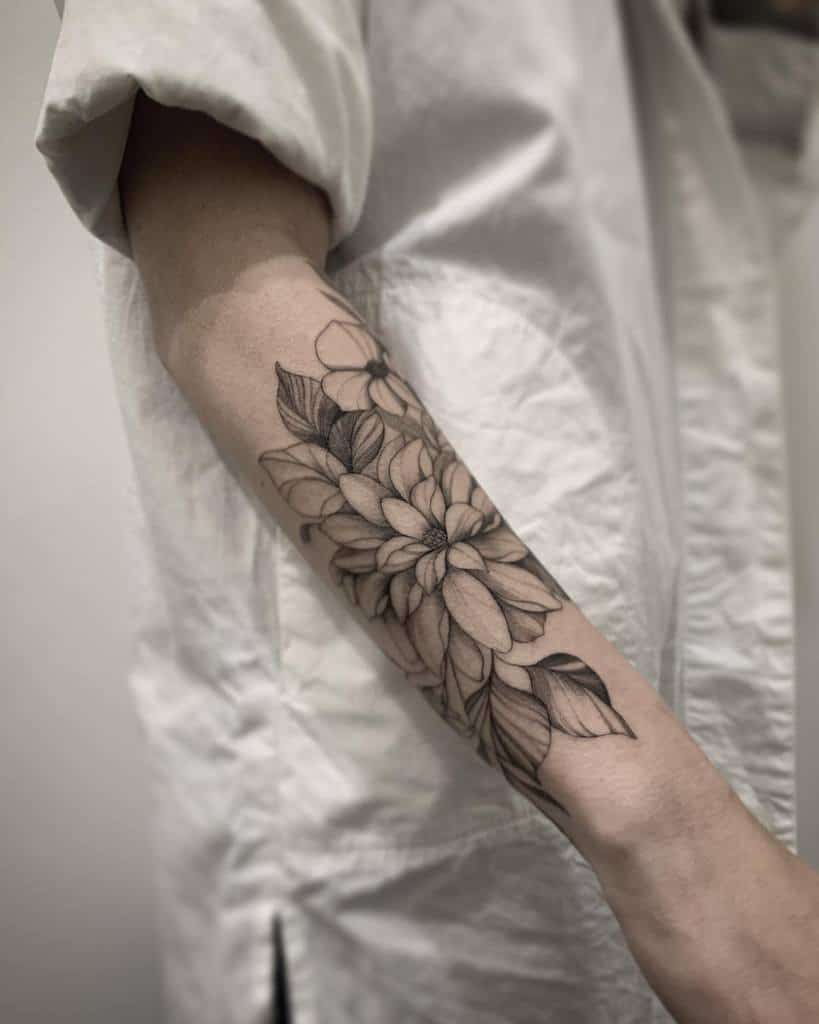 A tattoo of a floral design graces the outer forearm