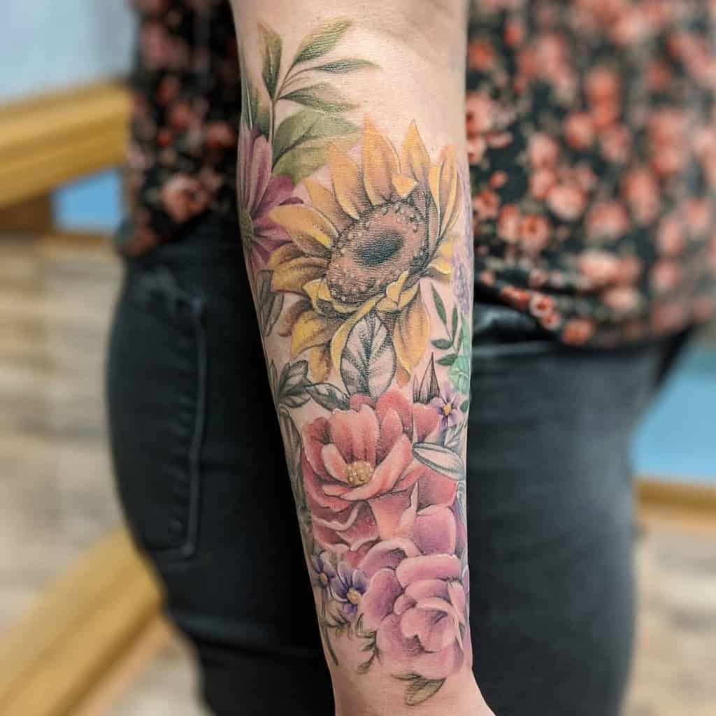 Outer forearm tattoo of sunflowers and roses in vibrant colors