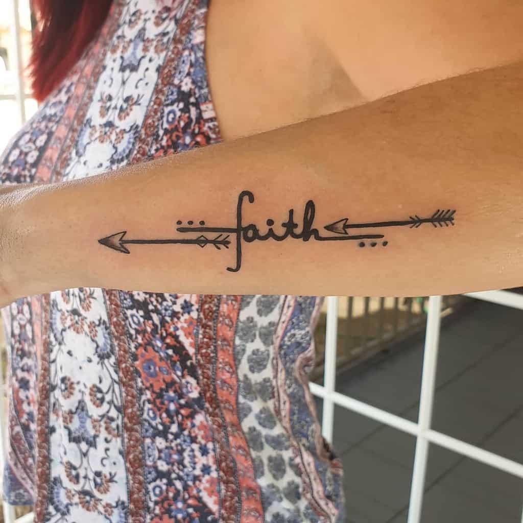 Tattoo of the word "faith" with arrows gracefully inked on the outer forearm