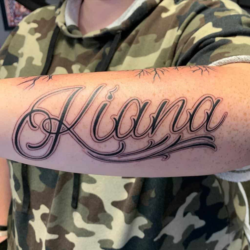 Outer forearm tattoo with the name "Kiana" in elegant script