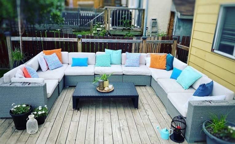 backyard wood deck large wicker sofa colorful cushions