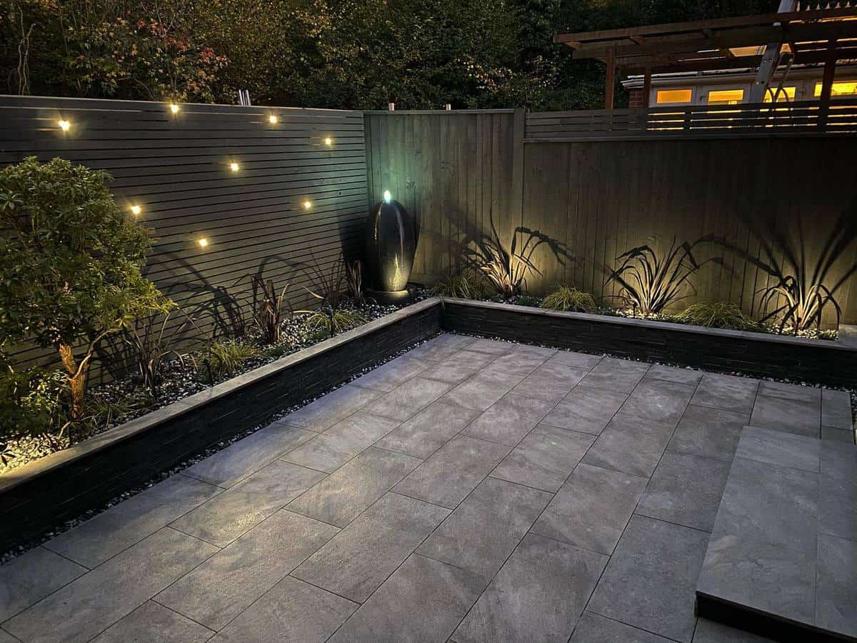 paved backyard hanging lights night