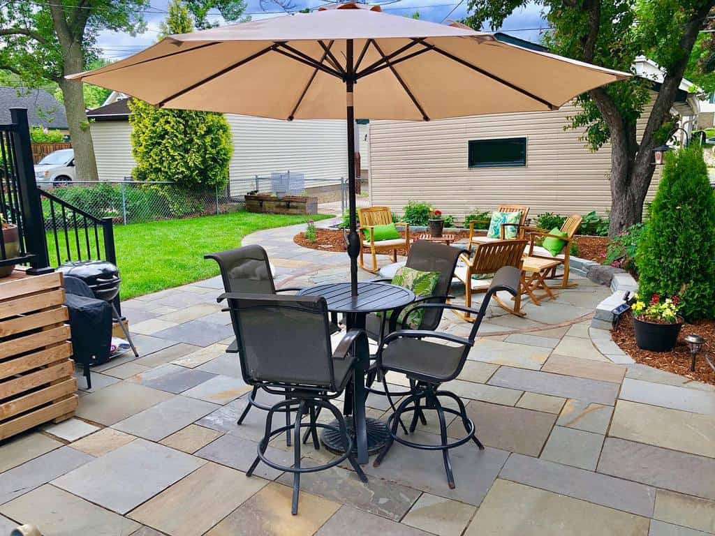 large paver patio with outdoor table and chairs 