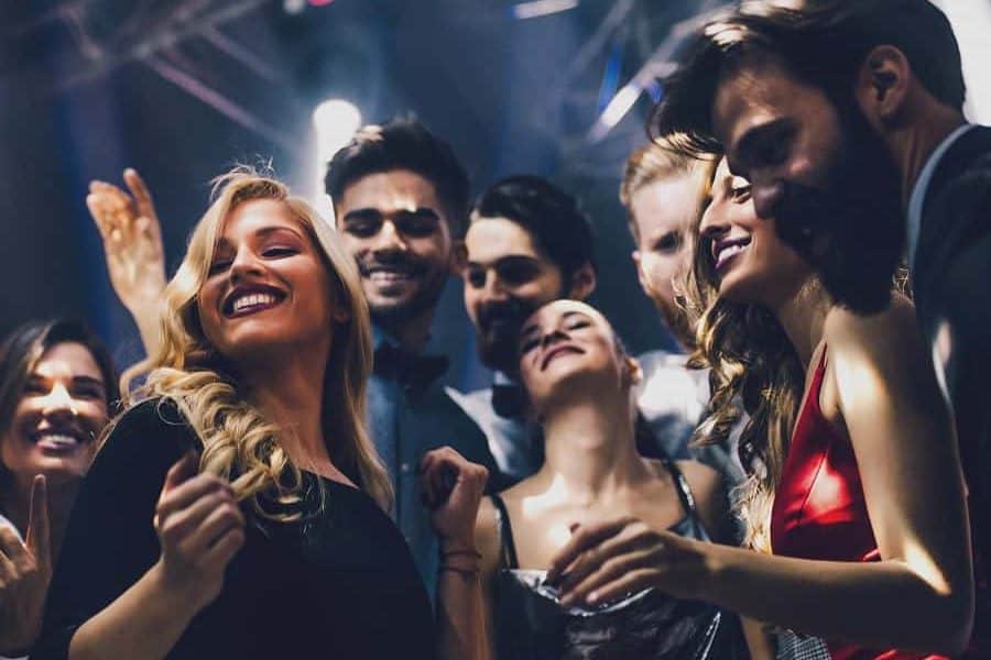 Group of people dancing and partying at a nightclub