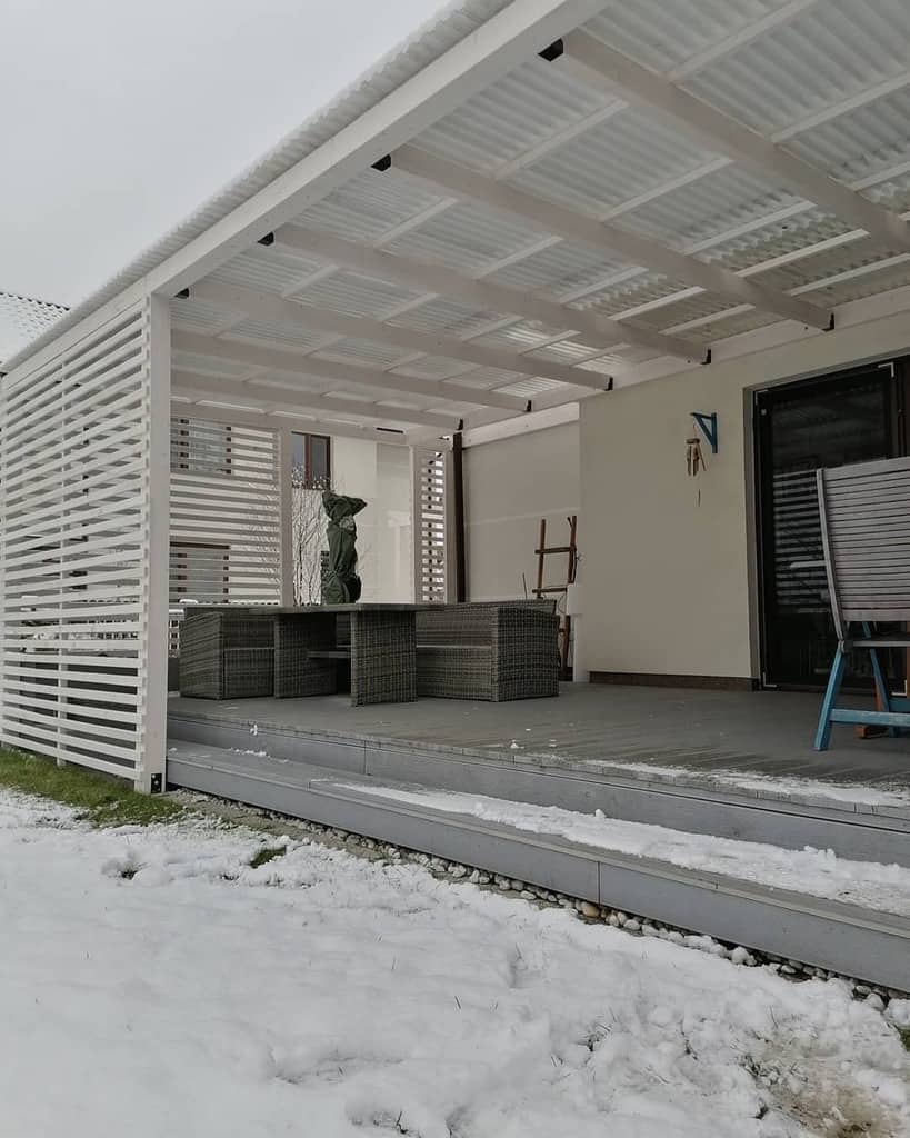 covered gray deck white walls wicker table and chairs
