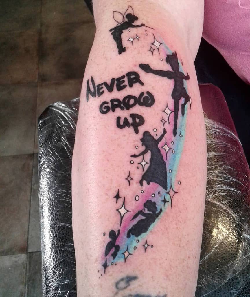 Tattoo with Tinker Bell, Peter Pan, Wendy, and the Darling children flying with the words "Never Grow Up"