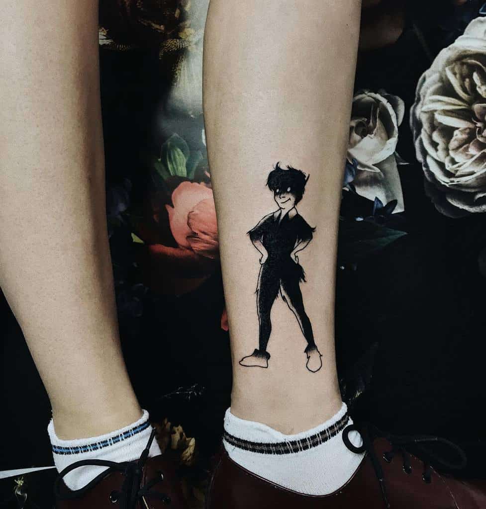 Peter Pan tattoo in black ink, featuring a playful stance with hands on hips