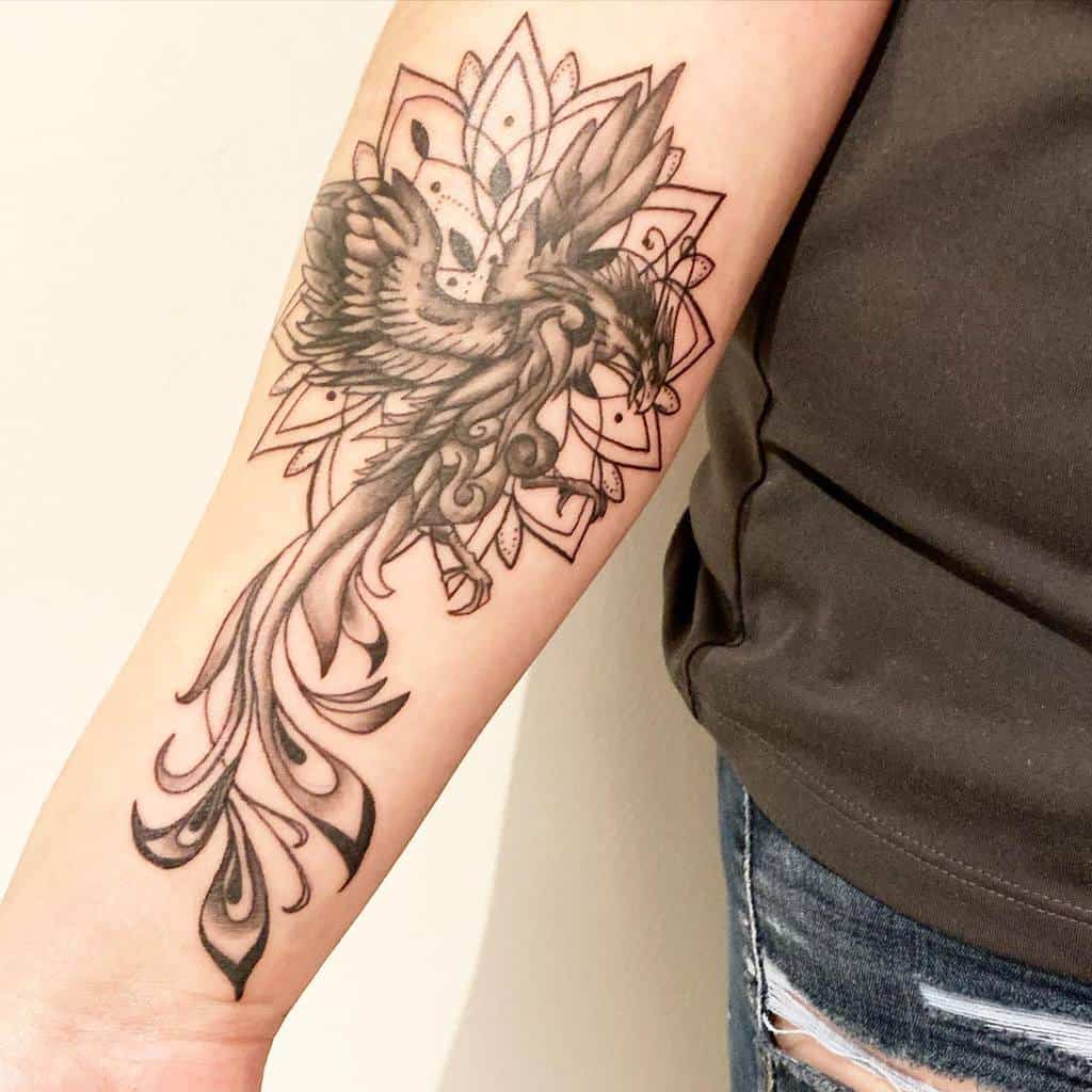 Forearm tattoo of a phoenix rising, with intricate, flowing details and a background of geometric shapes