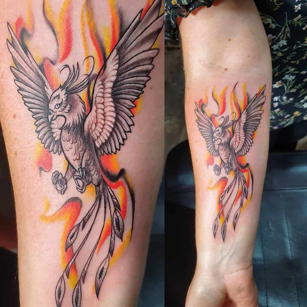 Tattoo of a phoenix rising with flames on an arm