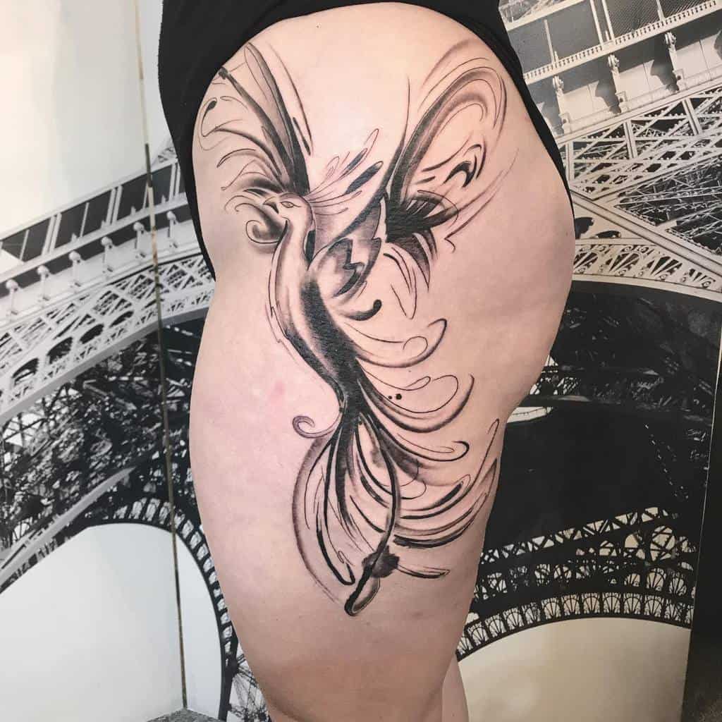 Tattoo of a phoenix in black ink covering a thigh