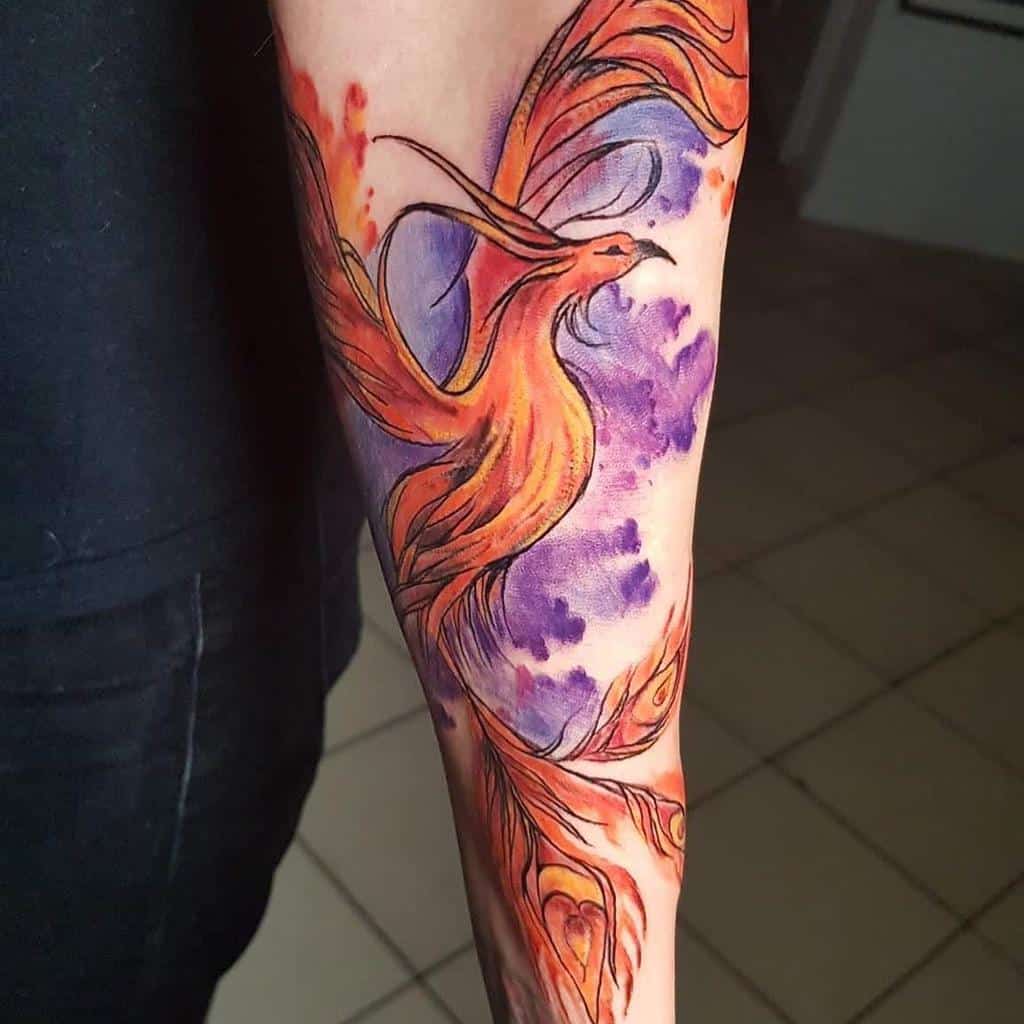 A vibrant phoenix tattoo with orange and purple hues on an arm