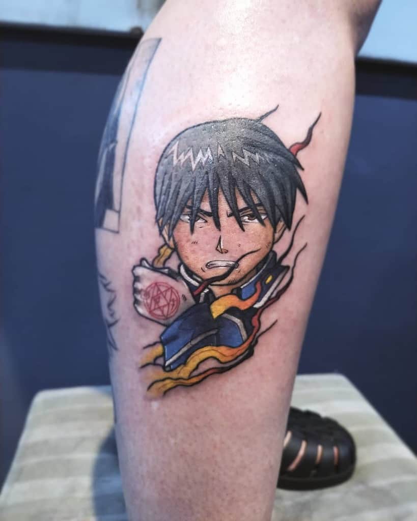 Fullmetal Alchemist tattoo of Roy Mustang emerging from a tear in the skin, showcasing his ignition glove’s transmutation circle with fiery details