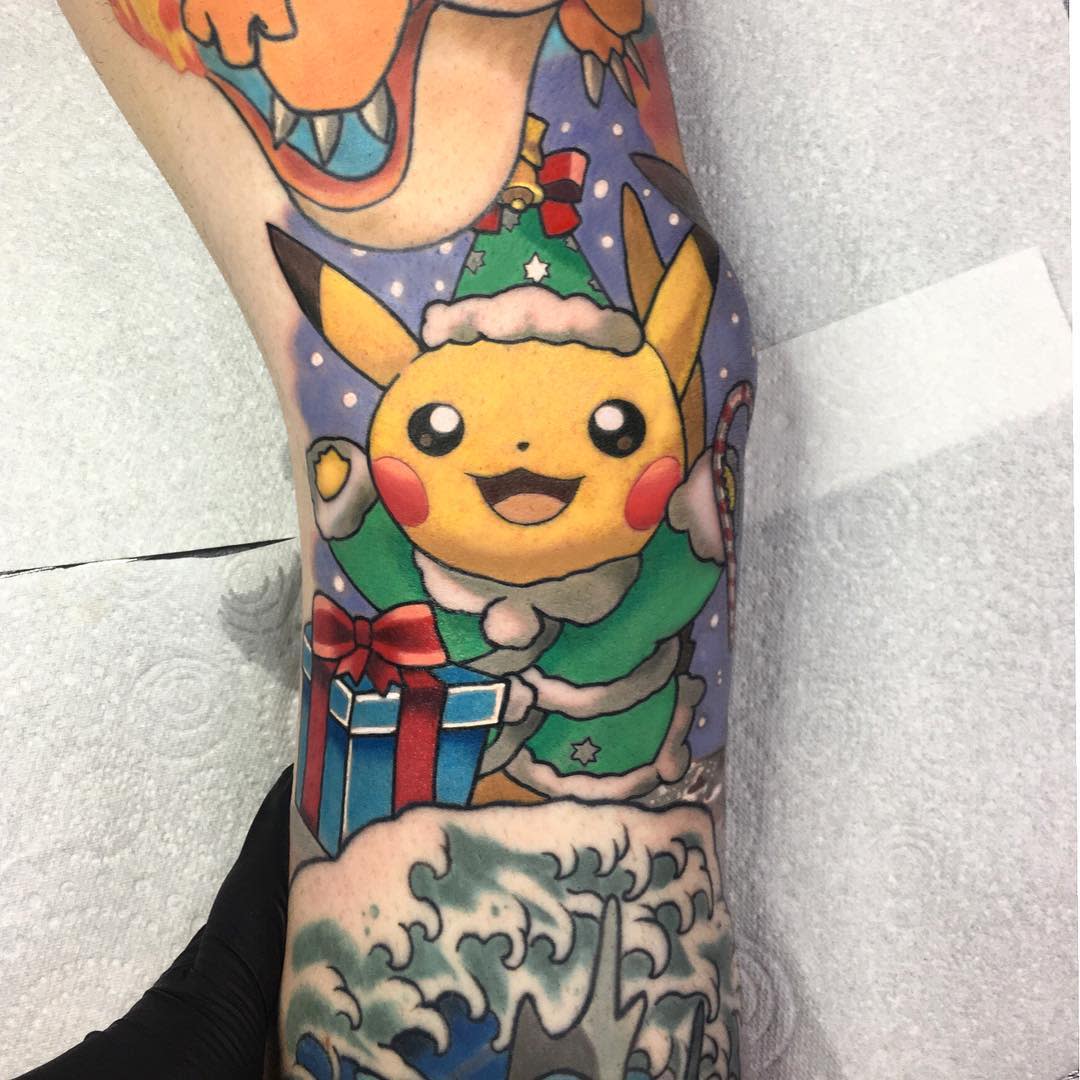 Christmas-themed Pikachu tattoo wearing a Santa hat, holding a gift box