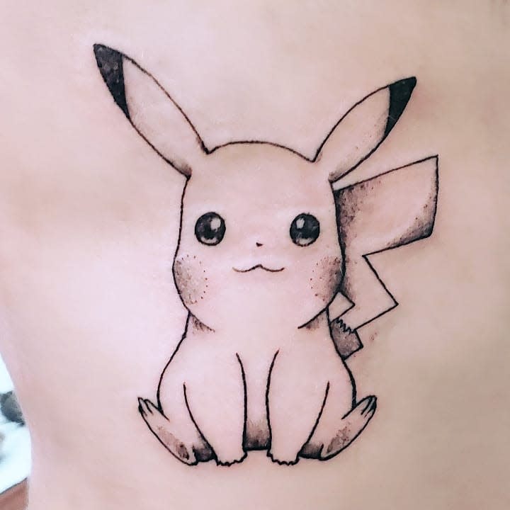 Tattoo of Pikachu, a cute yellow Pokémon, with a happy expression