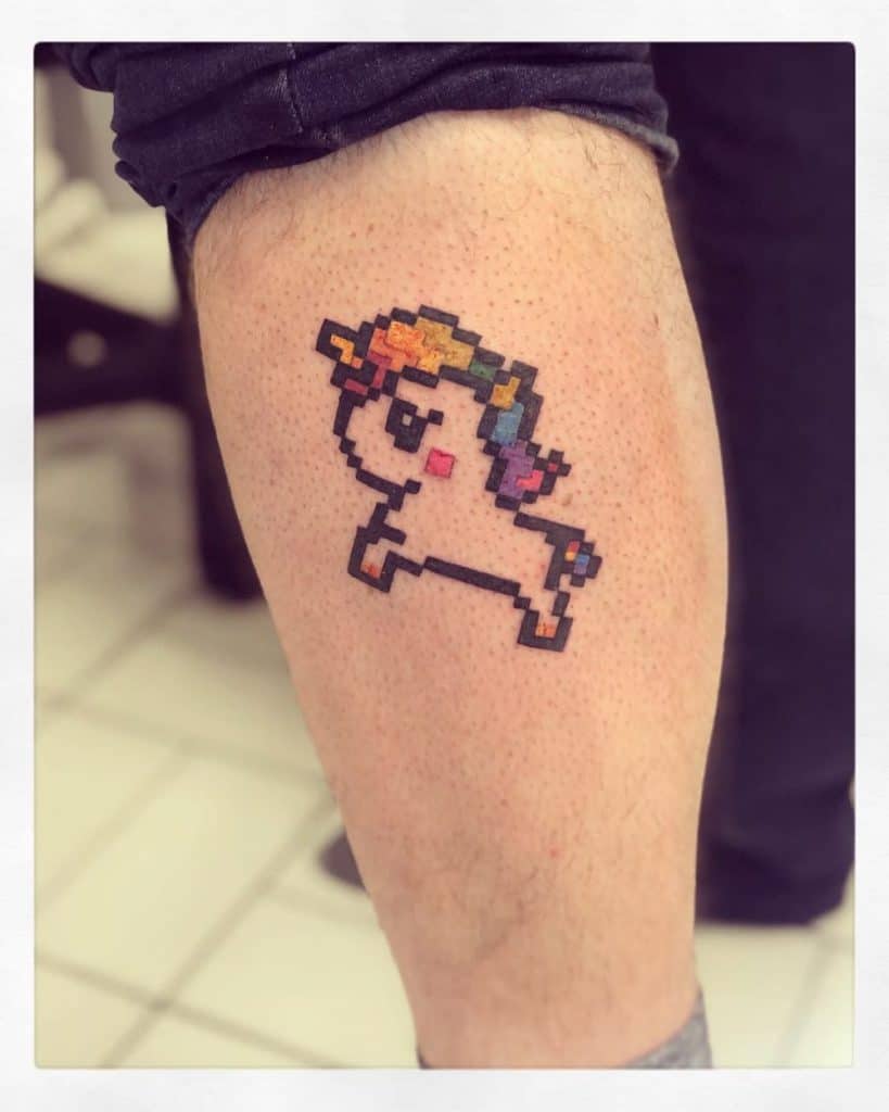 Pixel art-style tattoo of a unicorn with a rainbow mane and tail, designed in a retro 8-bit aesthetic for a nostalgic and playful look.