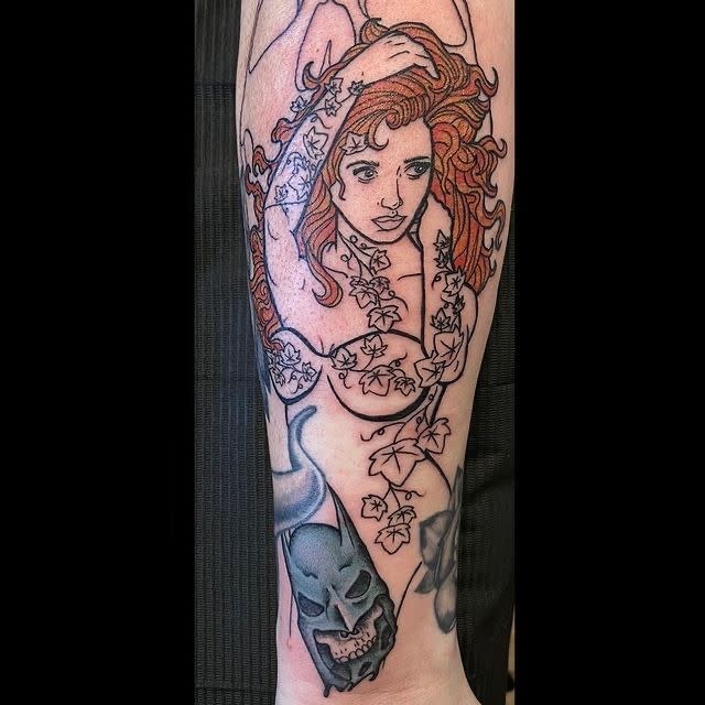 Forearm tattoo featuring a woman with long hair intertwined with ivy and a skull design