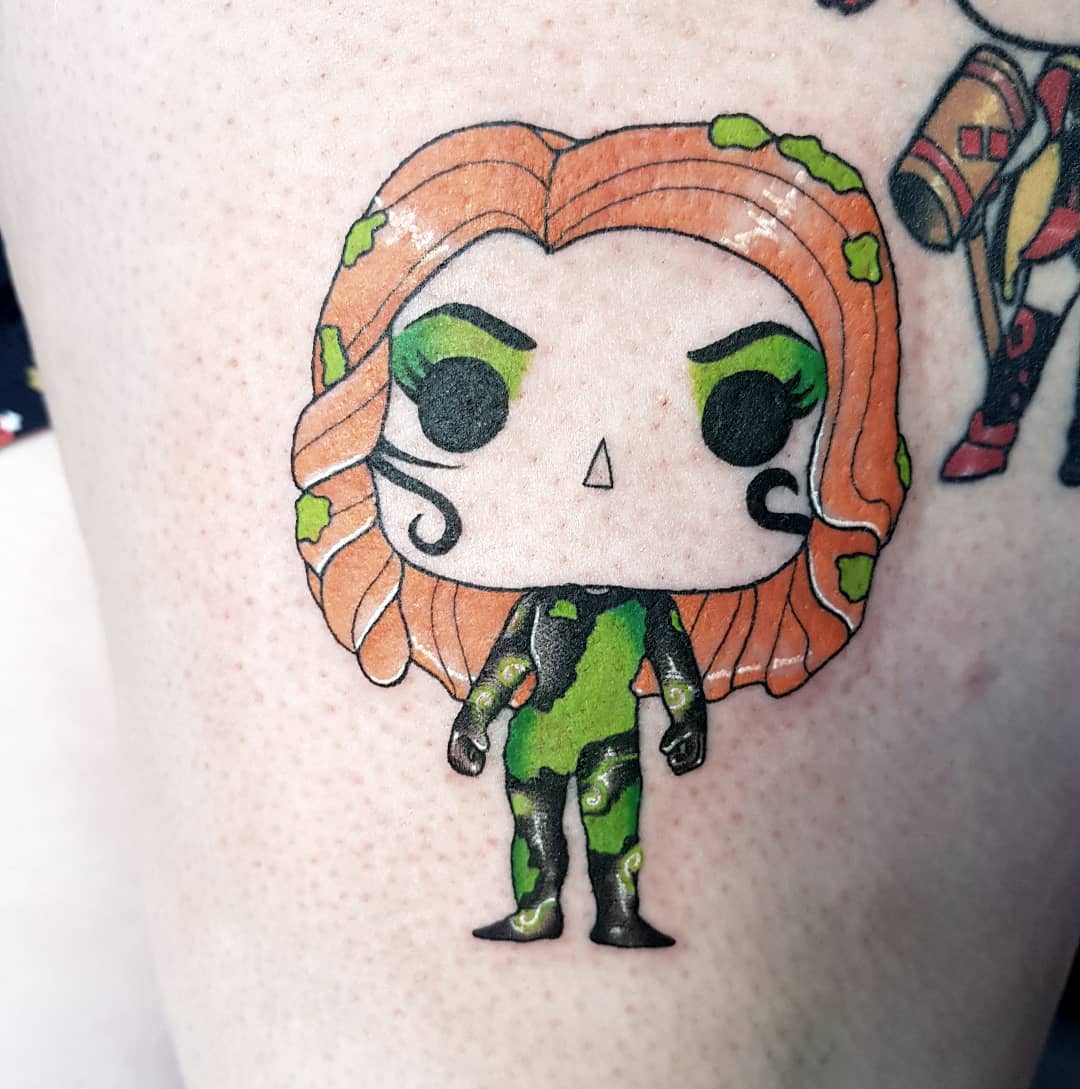 Tattoo featuring a chibi-style figure with vibrant orange hair and a green and black outfit