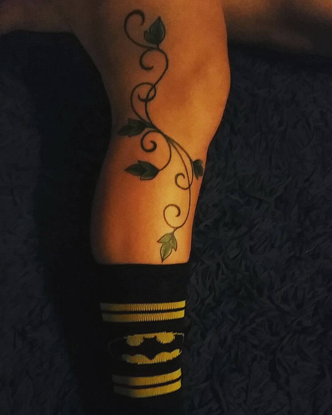 Leg with green vine tattoo