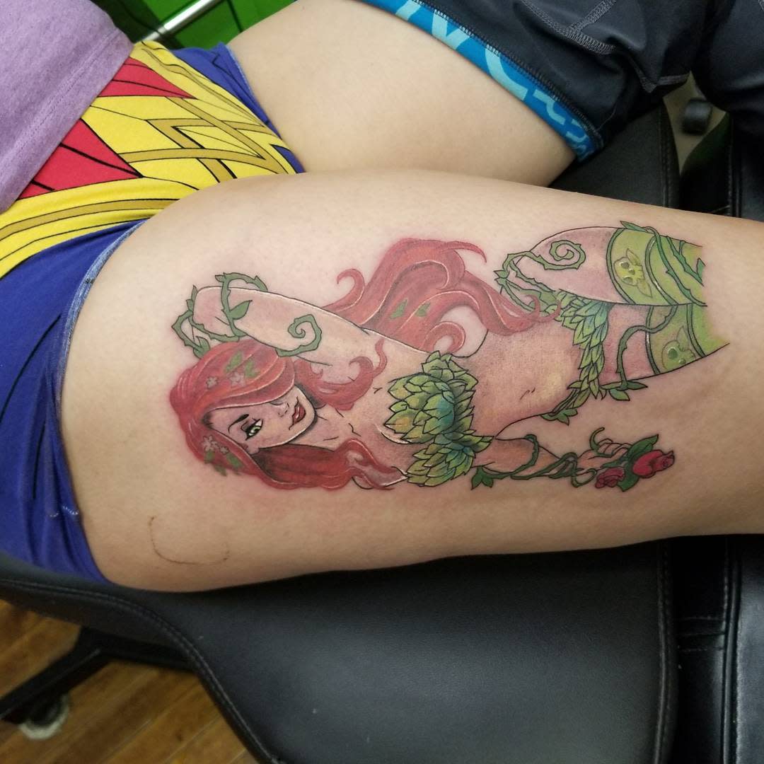 Tattoo of a female character with red hair and green outfit on thigh