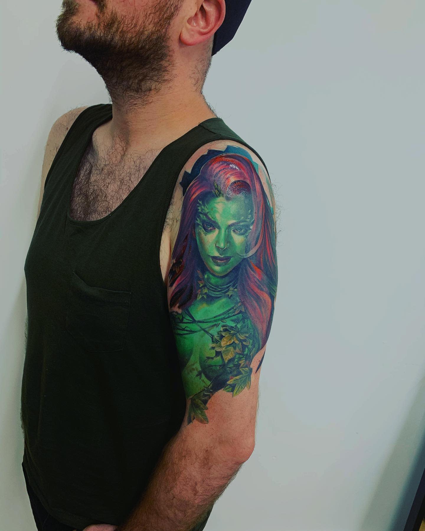 Detailed arm tattoo of a green and red-haired woman
