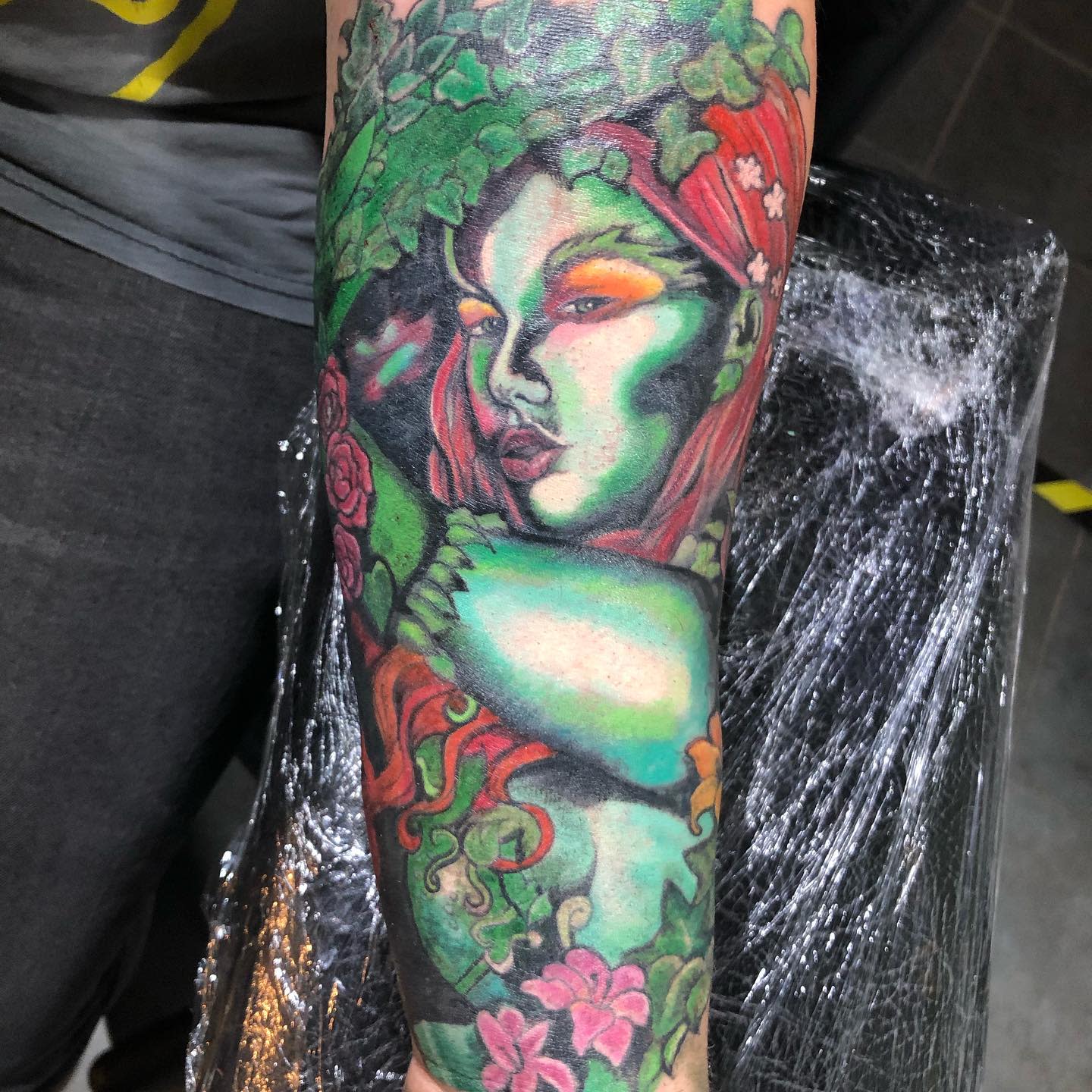 Colorful tattoo of a Poison Ivy with green skin and red hair