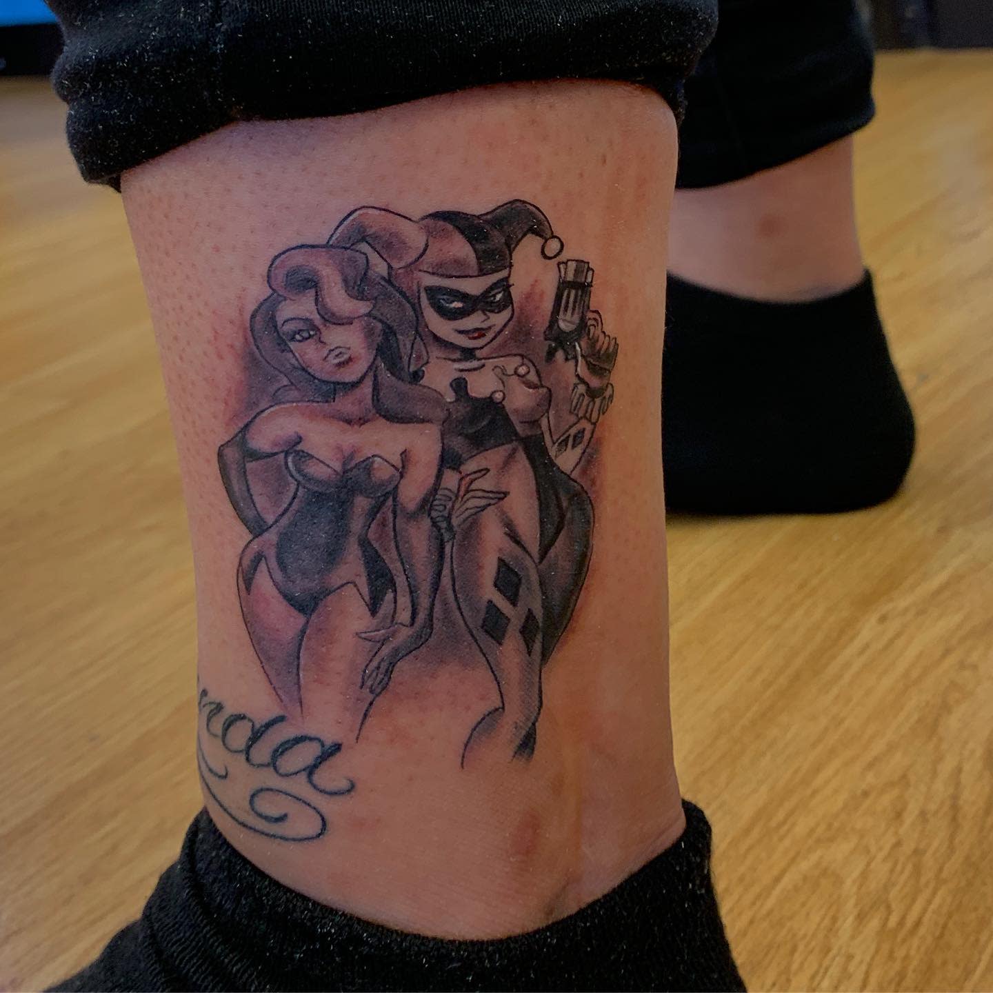 Tattoo of animated characters Harley Quinn and Poison Ivy on a leg