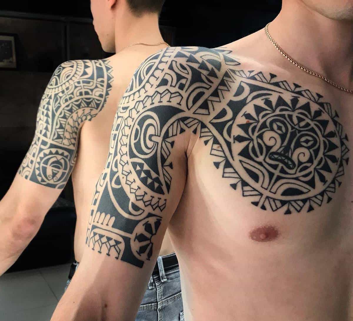 Itricate Polynesian tribal tattoos on mans' shoulder and upper arm