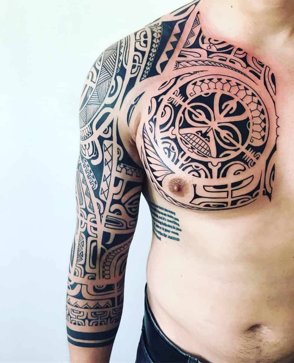 Individual adorned with intricate Polynesian-inspired tattoos covering their chest, shoulder, and full arm