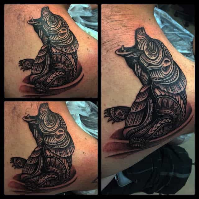 Tattoo of an ornate bear design in three distinctive angles, exquisitely showcasing intricate Polynesian patterns and masterful shading