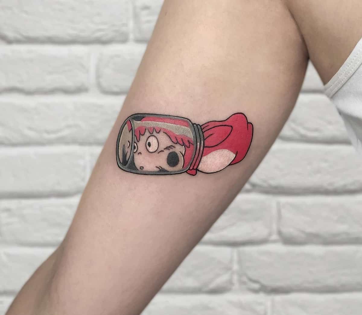Colorful tattoo of Ponyo trapped in a jar from Studio Ghibli's Ponyo on the upper arm