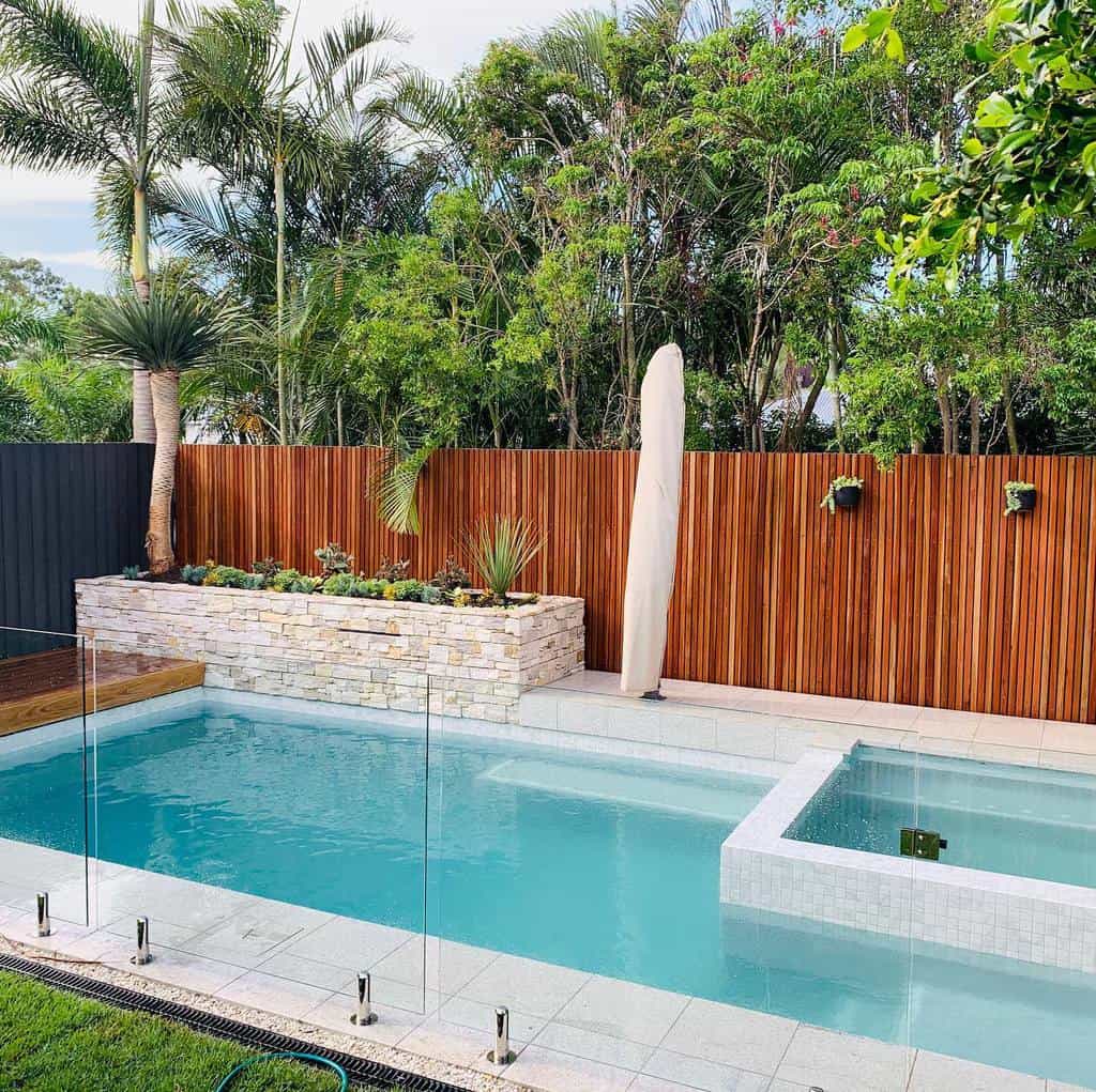 backyard pool wood fence paver garden bed