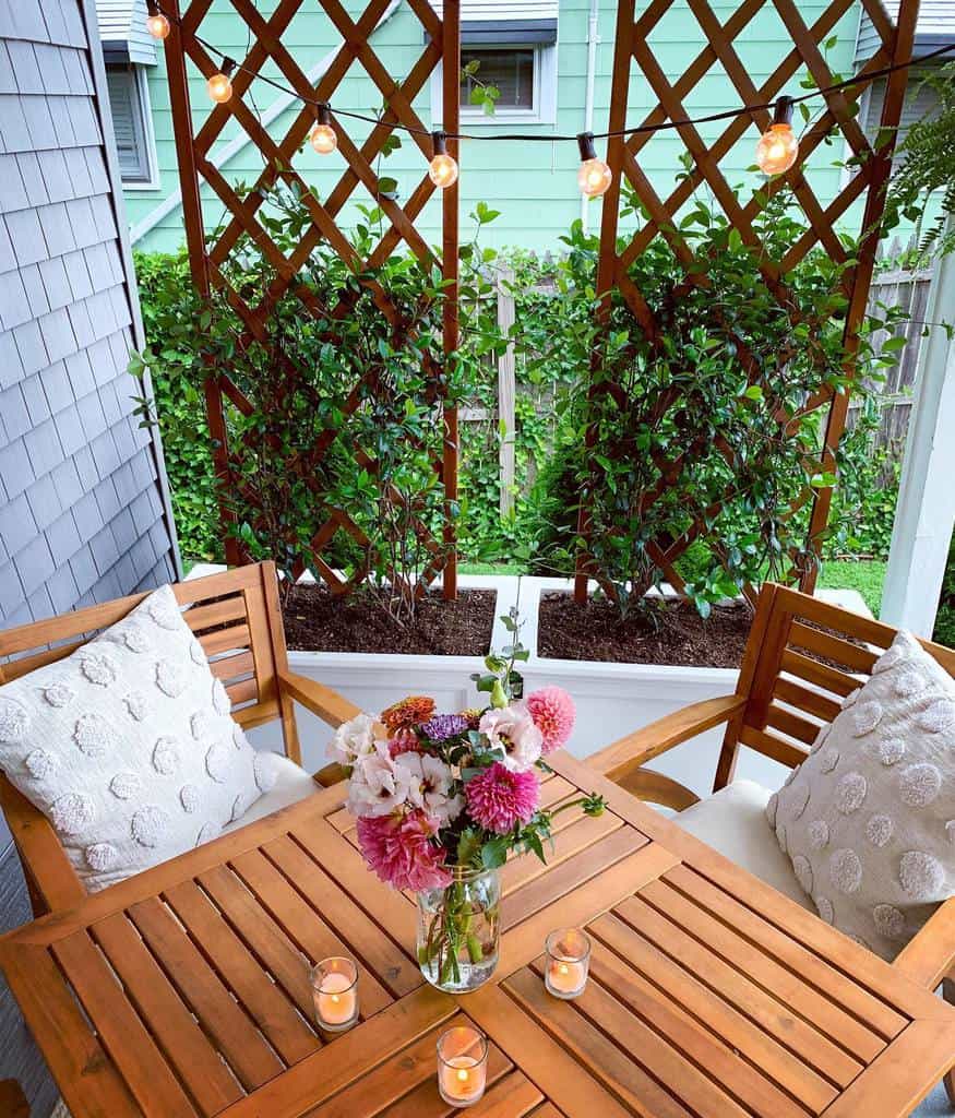 private patio wood table and chairs lattice work with plants