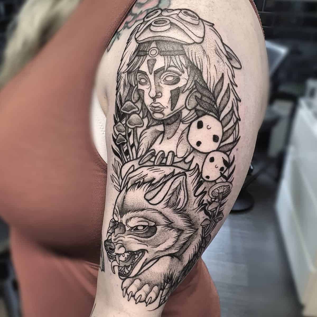 Detailed black and gray tattoo of San, Moro, and Kodama spirits from Princess Mononoke on the upper arm