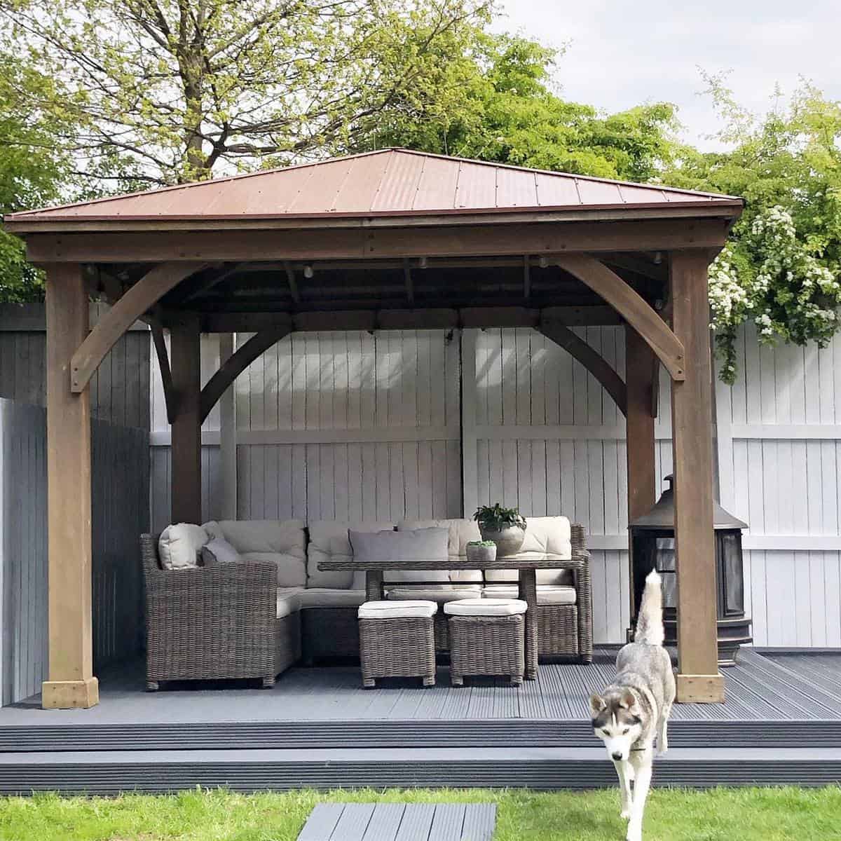 gray deck patio with pergola and wicker furniture 