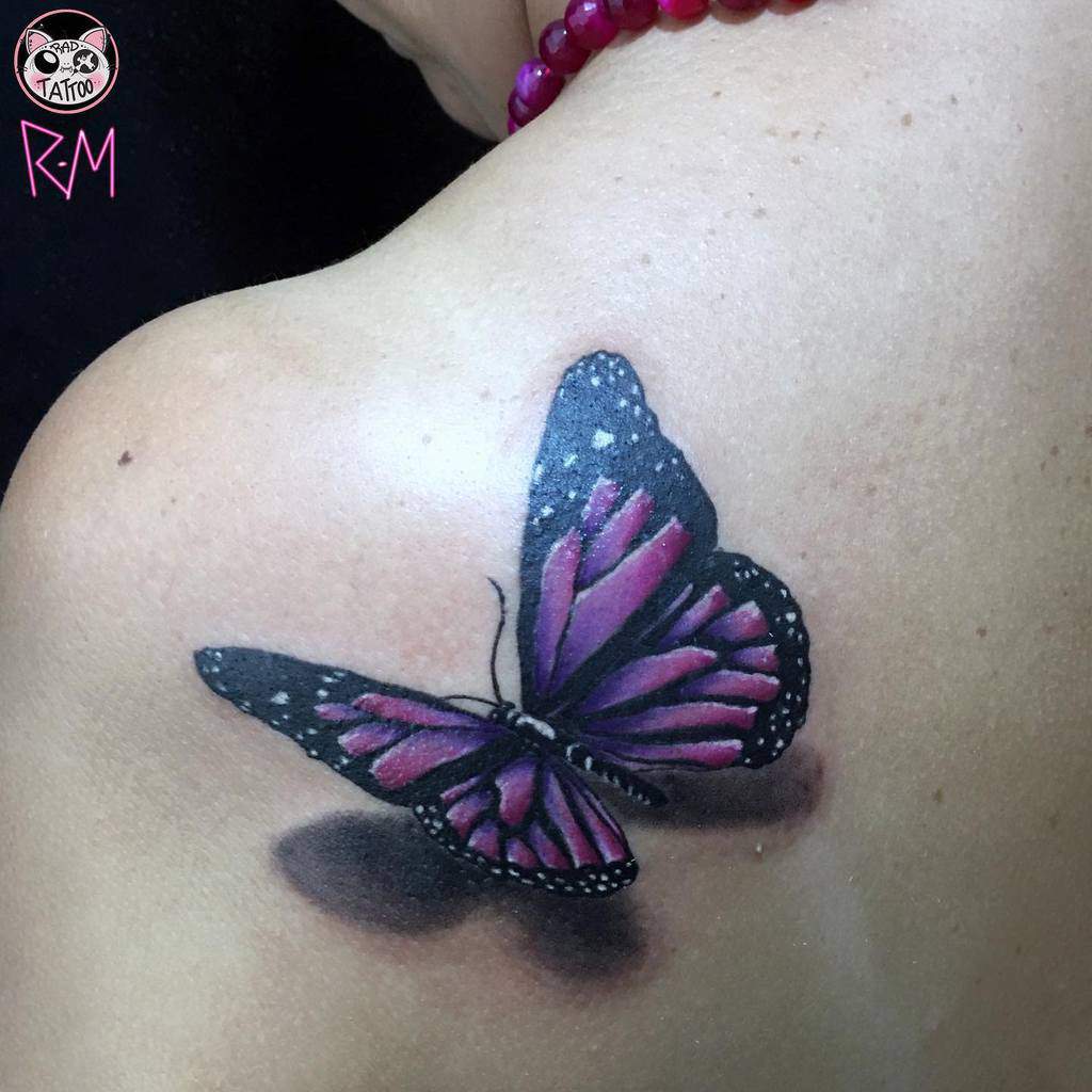 Tattoo of a purple and black butterfly on a shoulder