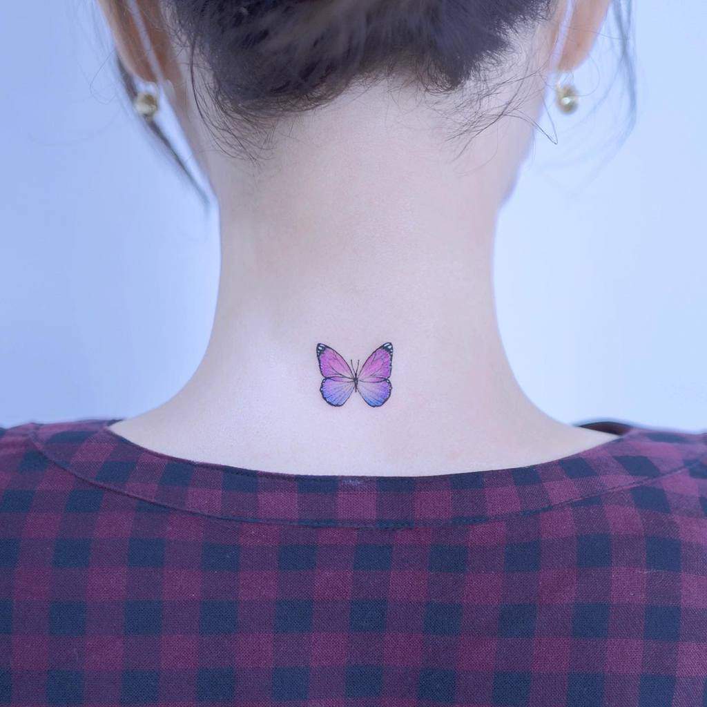 A purple butterfly tattoo on the back of a neck