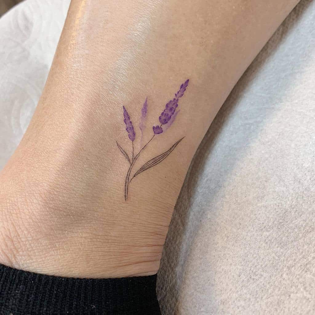 A minimalist lavender tattoo on an ankle, showcasing delicate purple flowers with lush green stems