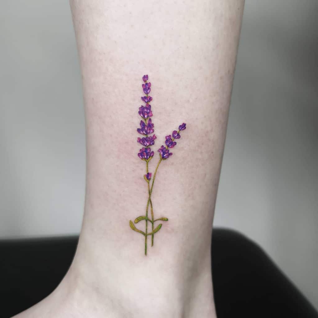 A simple lavender tattoo with vibrant purple flowers on the ankle