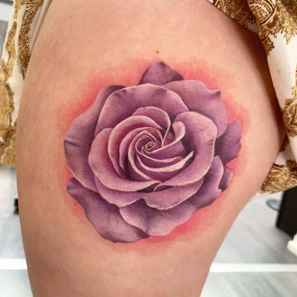 A purple rose tattoo on the upper thigh, its petals enriched with deep red shading along the edges