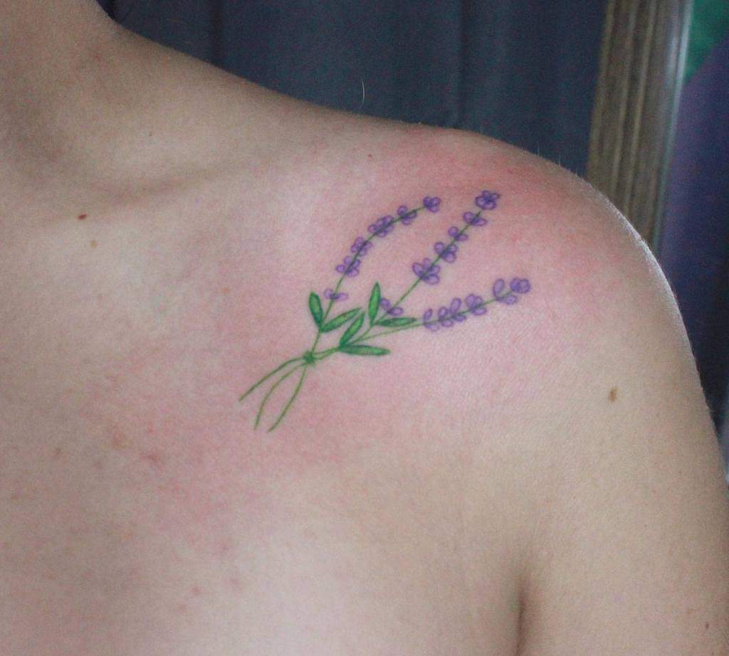 A floral tattoo of lavender sprigs on a shoulder