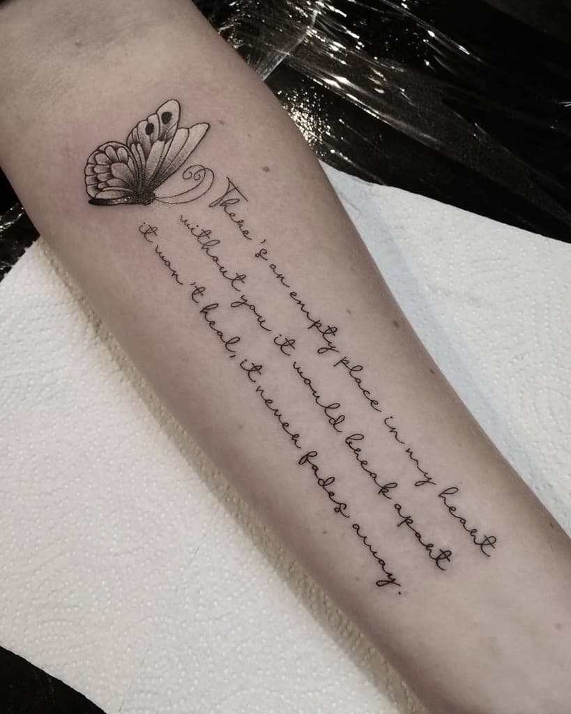 Forearm tattoo of a butterfly and cursive text